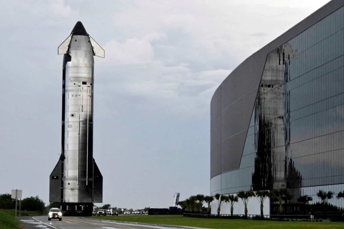 Una nave espacial Starship de SpaceX se desplaza hacia su plataforma de lanzamiento, pasando junto a las instalaciones de fabricación de Starbase, en agosto de 2025.